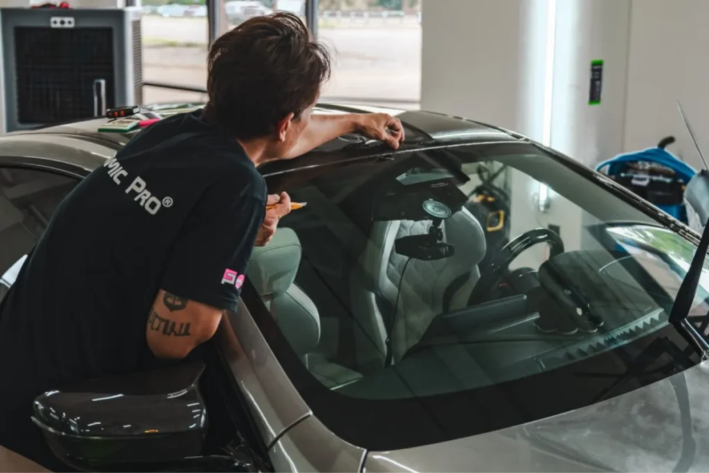 Windshield protection film installation on a car.