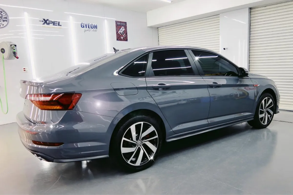 Gray Volkswagen sedan with dark window tint.
